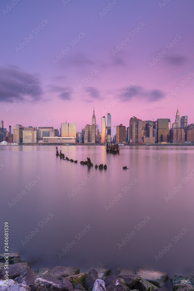 View on Midtown Manhattan from east river at sunrise with long exposure View on Midtown Manhattan from east river at sunrise with long exposure