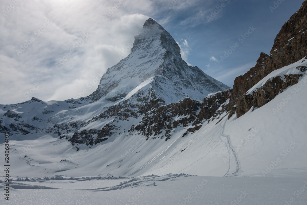 Majestic Matterhorn mountain in front of a partly cloudy sky