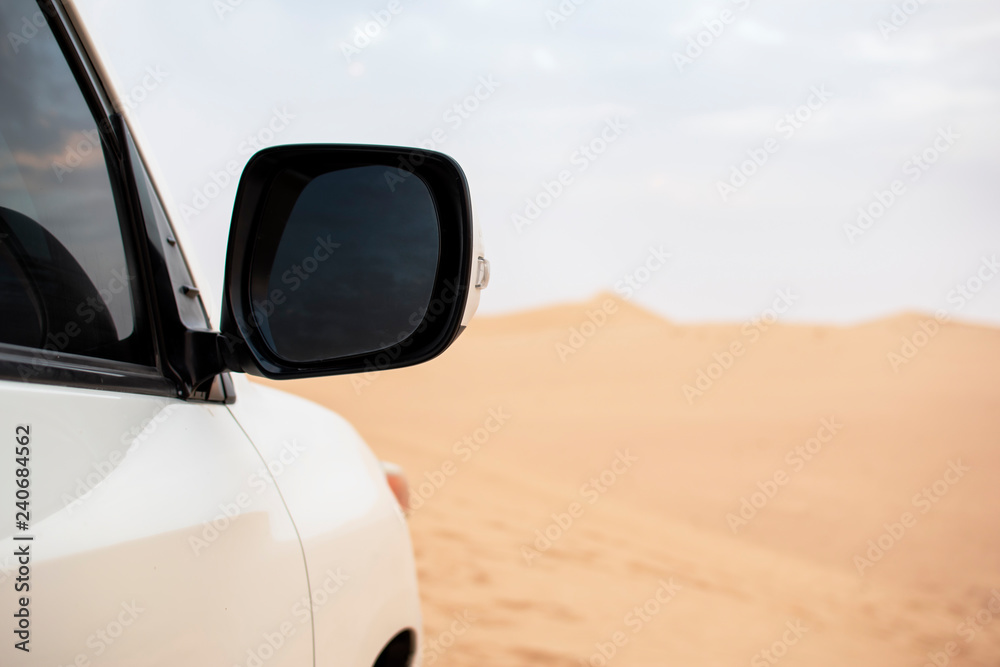 Side mirror of a car in a desolate landscape