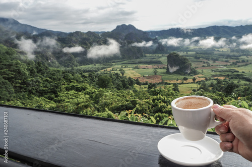 coffee cup on table with Mountain views in the morning as a background