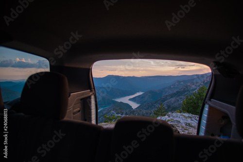 Enjoying the view on a peak of the mountain from inside the all terrain vehicle at sunset.