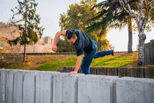 Parkour guy training on obstacles in park