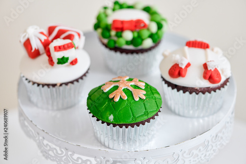 Seasonal festive christmas mini dessert cupcakes in traditional red green decorative symbols elements