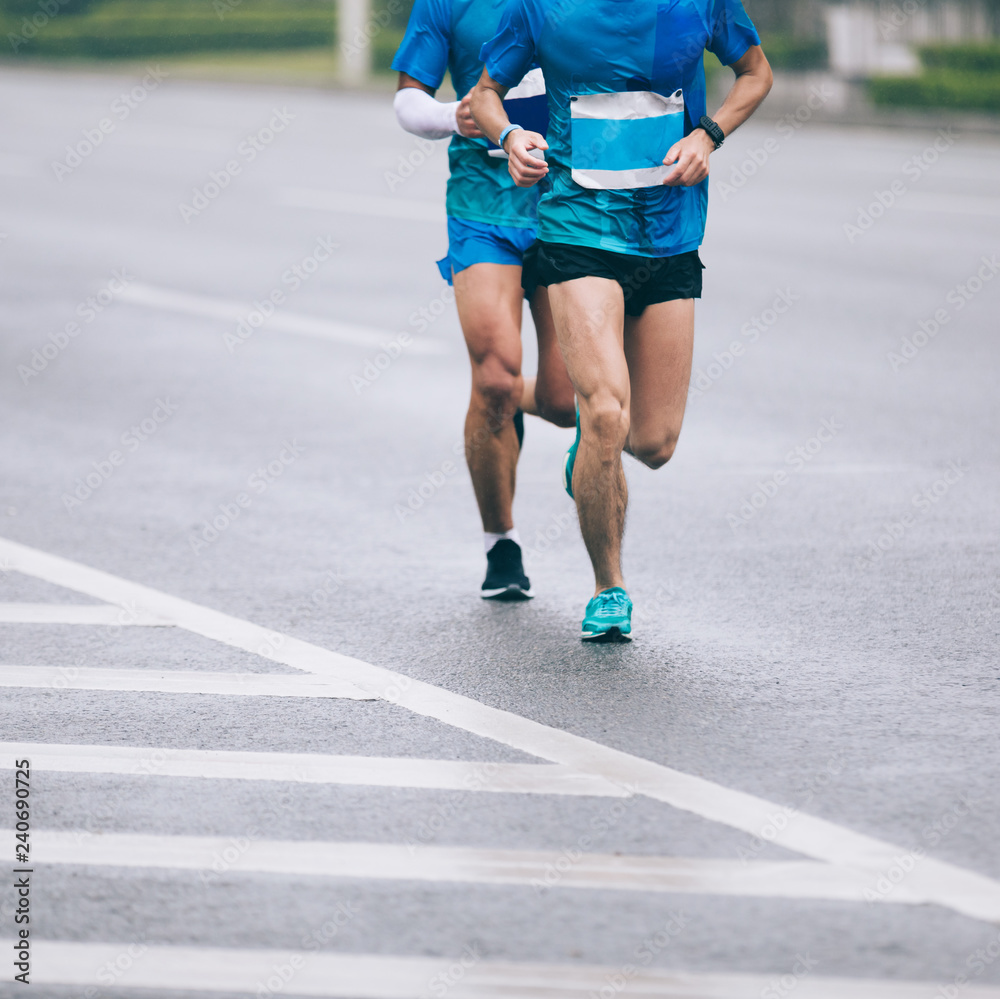 Marathon runner legs running on city road