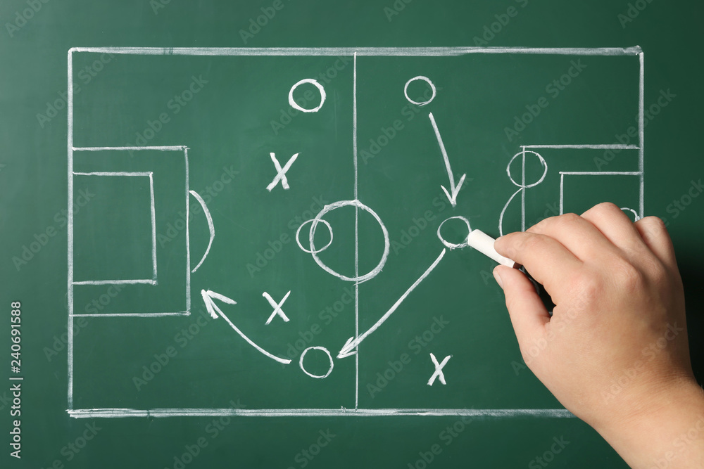 Woman drawing football game scheme on chalkboard, top view