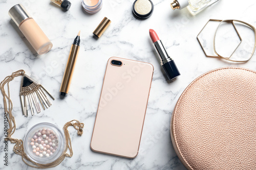 Flat lay composition with lipstick and smartphone on marble background
