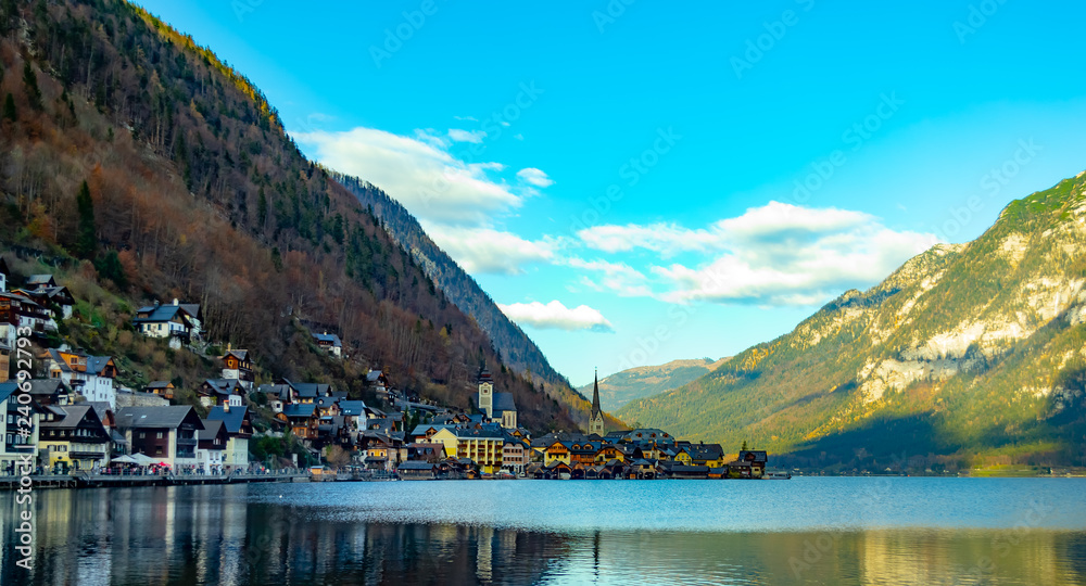 mountain village, on the bank of the lake, beautiful houses, on the background of high mountains, mountains covered with trees and pines, beautiful sky, beautiful nature, lake