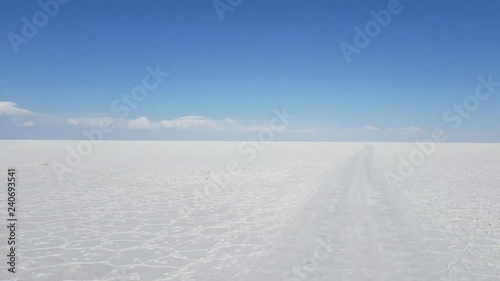 Driving through The Uyuni Salar in Bolivia. White salt flats and a bright blue sky. South a=America
