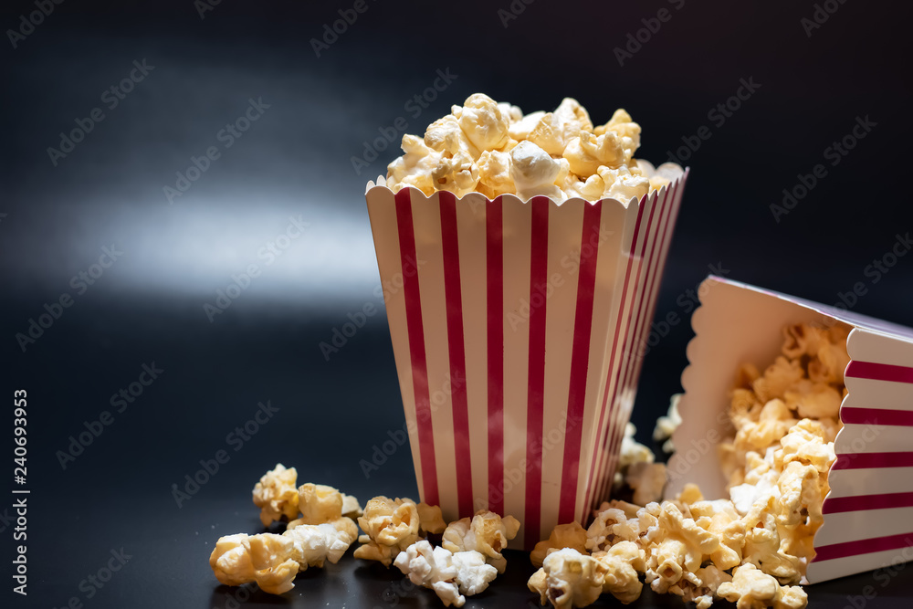 Popcorn in a box spread on a colored backgroung