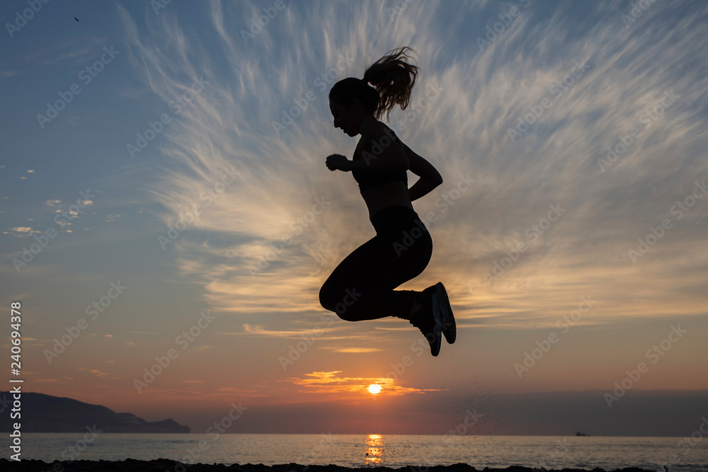 young woman does exercise at sunrise