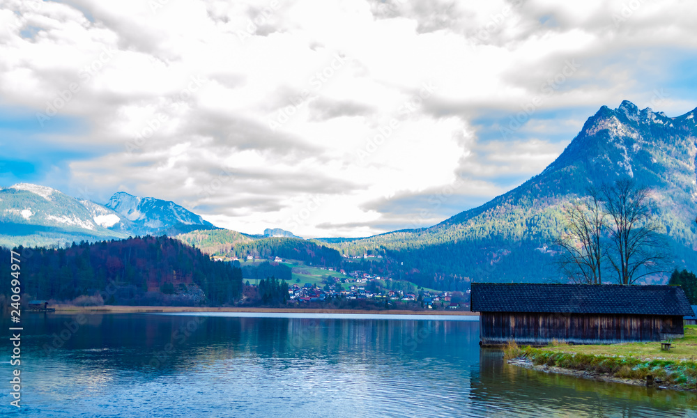 The lake is surrounded by beautiful mountains, mountains, pines, trees, spring, wooden houses
