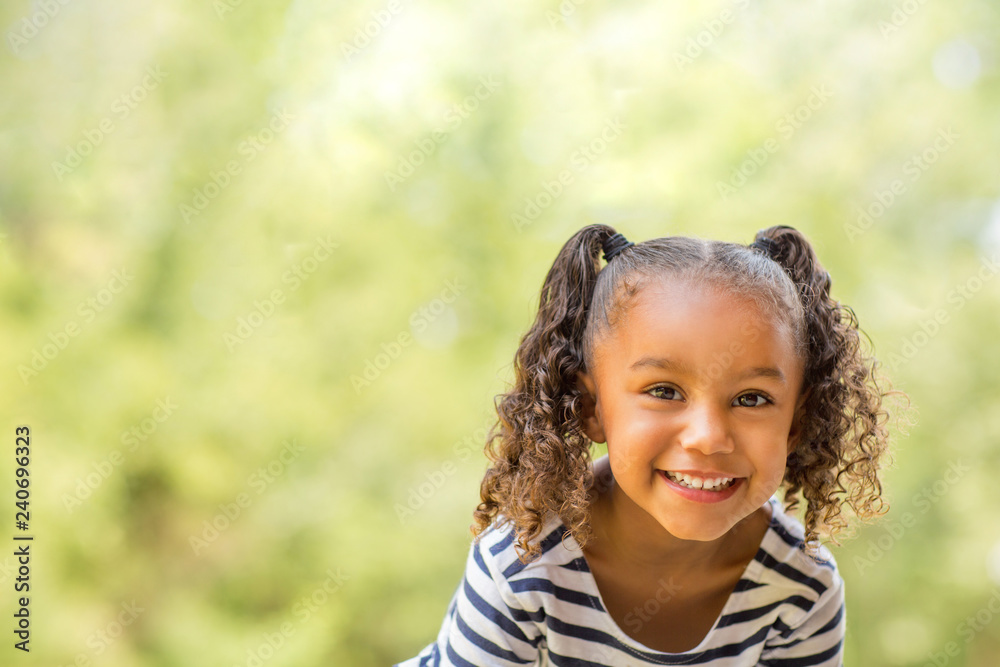 Cute mixed race little girl laughing and smiling. - obrazy, fototapety, plakaty 
