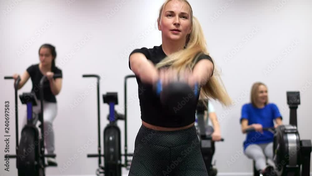Girl squats, holds a dumbbell in the fitness room. Girl squats, holds a dumbbell in the fitness room.