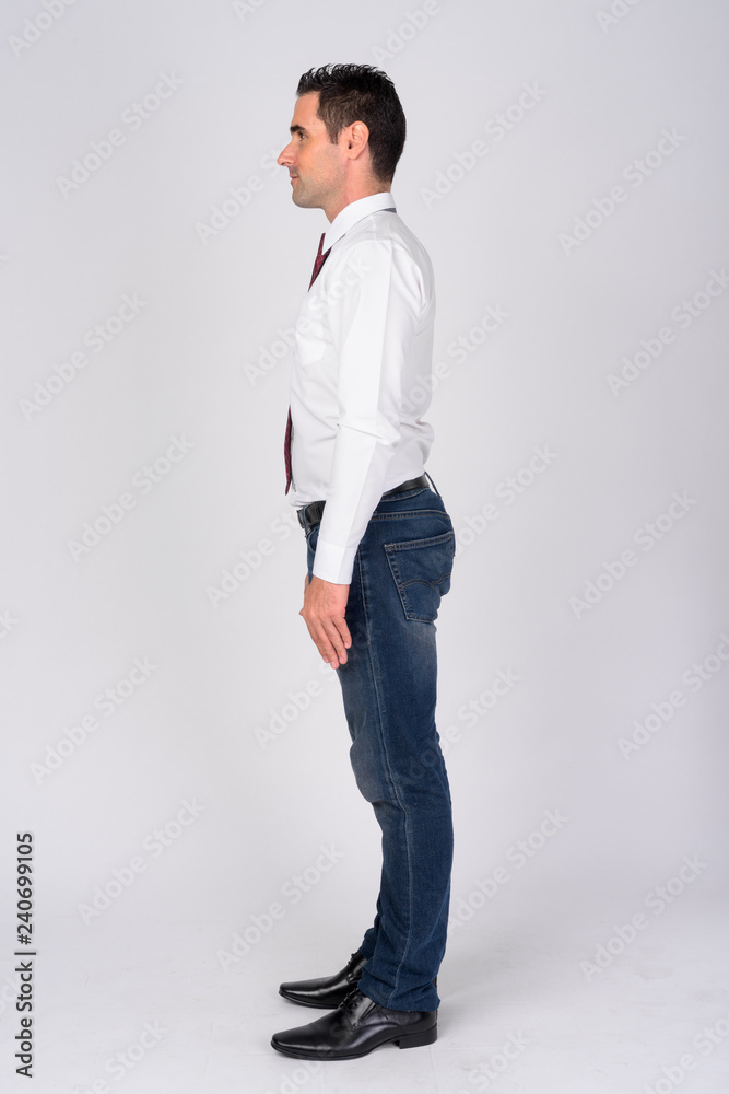 Full body shot profile view of handsome businessman against white background