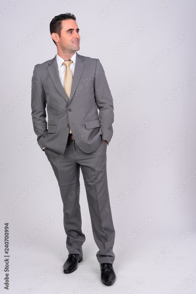 Full body shot of happy businessman smiling while thinking Full body shot of happy businessman smiling while thinking