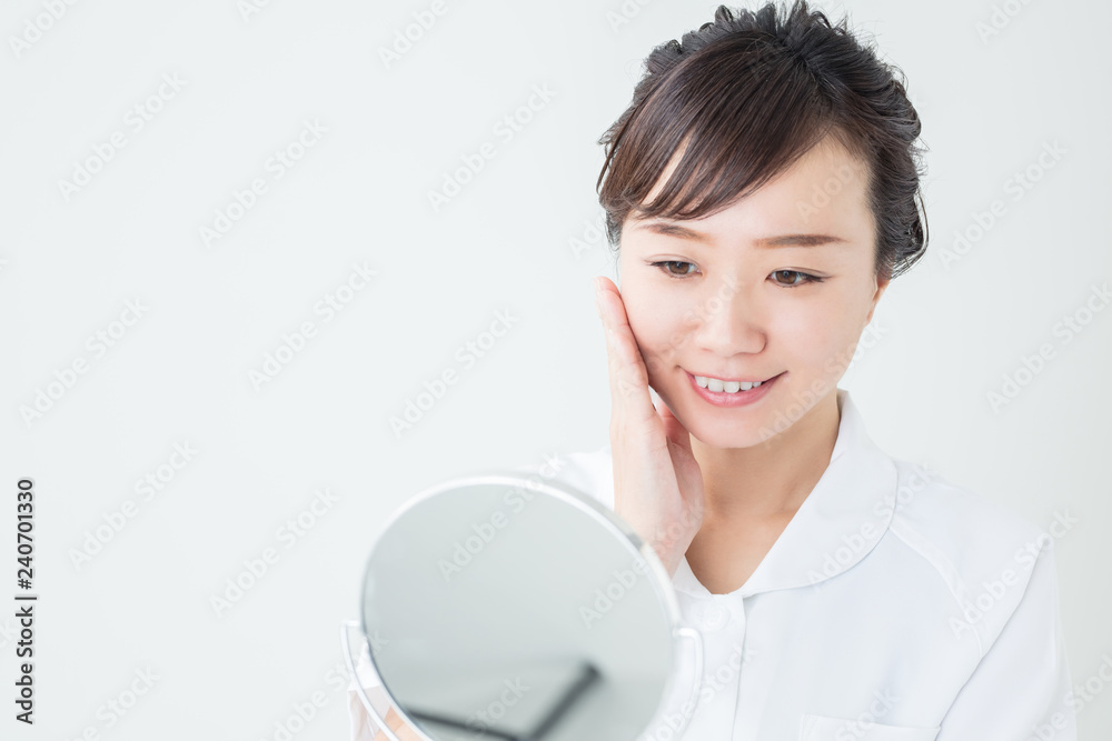 白衣を着て鏡で自分を見る女性
