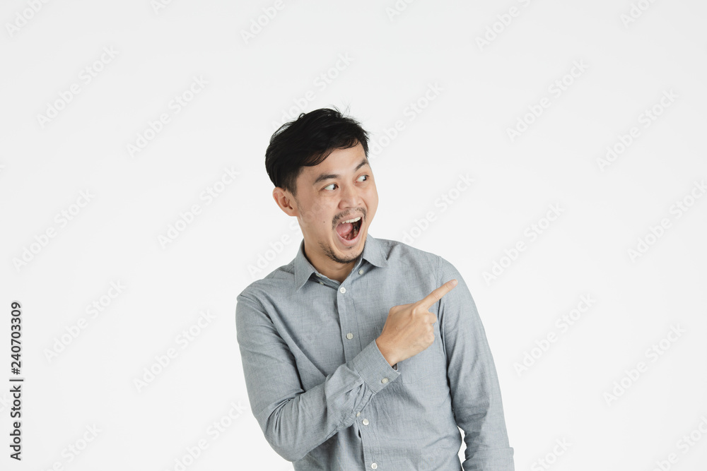 Asian young man pointing at something imaginary Asian young man pointing at something imaginary