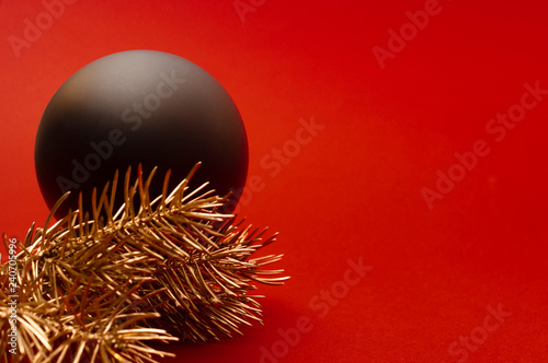 Close up of golden Christmas tree branches and big black bauble. Concept
