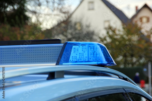 Police car with blue light siren on spot in the street