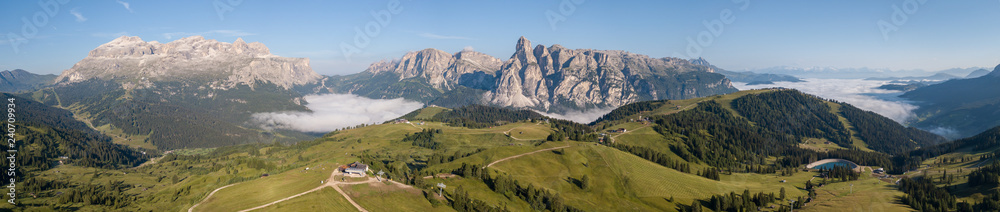 Dolomites, Italy, Alta Badia, Sud Tirol. Drone aerial view of the fog at the bottom of the valley in summer time
