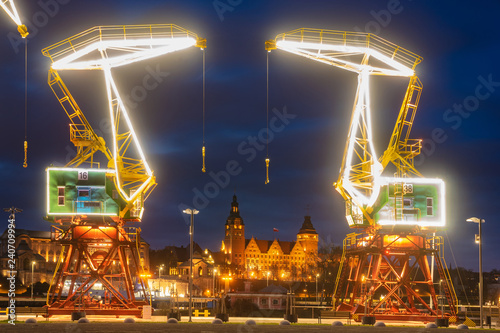 Illuminated old port cranes on a boulevard in Szczecin City at night