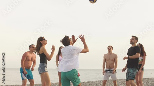young people group have fun and play beach volleyball at summer day