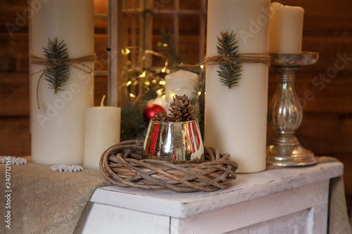 christmas decoration with white candles cones and a wreath