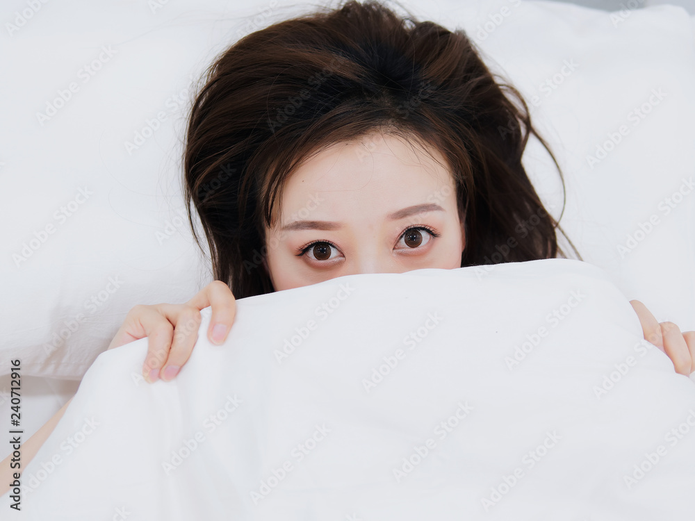 Funny surprised girl covering half of face with white blanket, young scared woman hiding and peeking from duvet, afraid of night monsters, feels embarrassed, wide awake, head shot close up, top view. Funny surprised girl covering half of face with white blanket, young scared woman hiding and peeking from duvet, afraid of night monsters, feels embarrassed, wide awake, head shot close up, top view.