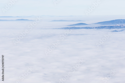 Fog filling a valley in Umbria (Italy), with layers of mountains and hills and various shades of blue © Massimo