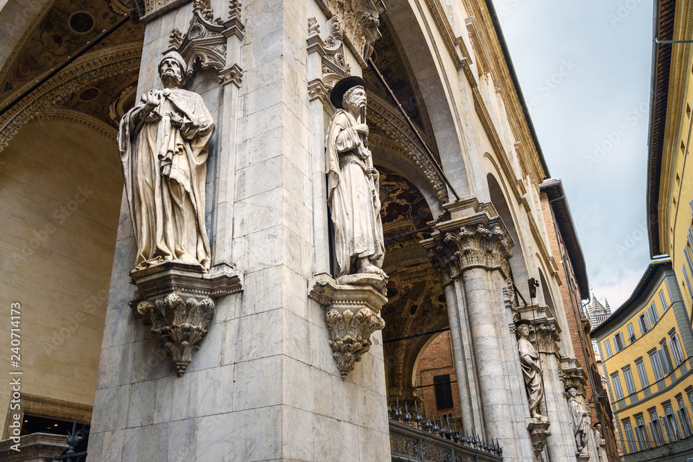 Statue of Saint Peter by Vecchietta and Statue of Saint Sabinus. Statues decorating facade of Loggia della mercanzia in Siena. Italy