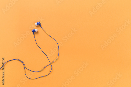 black earphones on colour background  top view