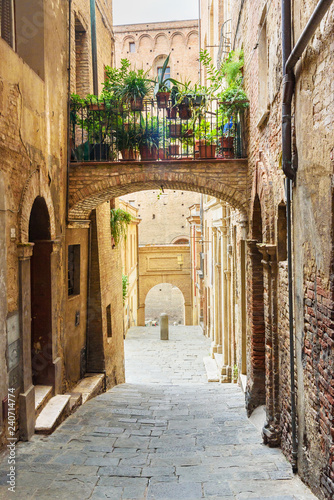 Medieval narrow street Vicolo Delle Scotte in Siena, Tuscany, Italy. photo