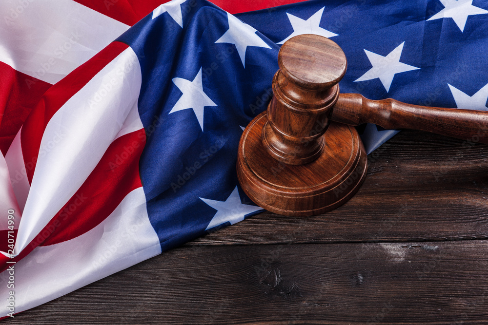 Wooden gavel and USA flag on table close up