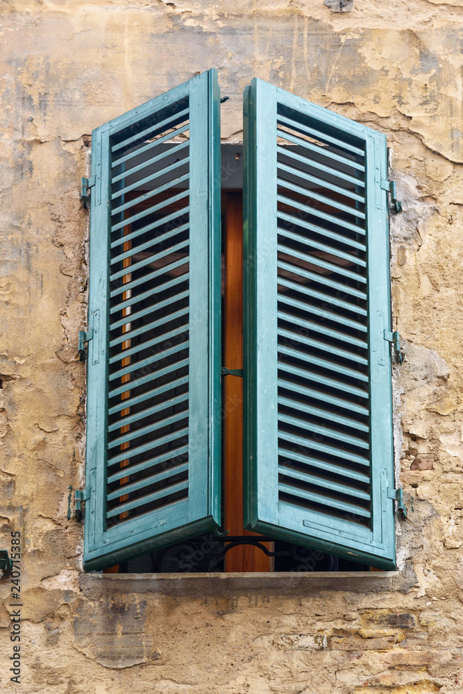 Fototapeta premium Window with wooden shutters of old house in Siena. Italy