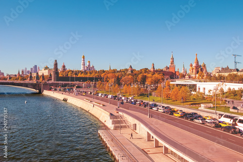 Aerial view from Moscow River on embankment with urban transport road and footpath. Moscow Kremlin and St Basil's Cathedral on background. Famous landmarks.