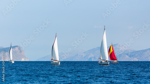 Sailing boats participate in yachting regatta.