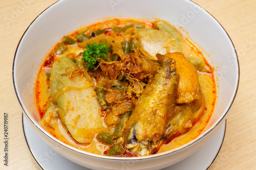 Indonesian or Malay food ketupat sayur or lontong sayur, rice cake with chicken curry on a bowl close up