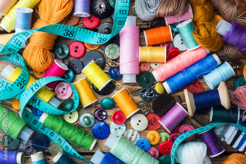 Sewing tool for needlework, colored threads centimeter and buttons with a pair of scissors on the table. close-up.