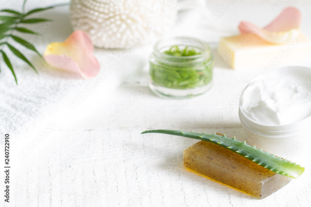 Natural cosmetics for skin care with petals rose and aloe vera on white planks
