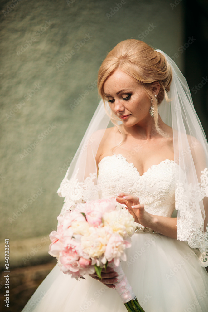 Naklejka premium Fantastic bride walk near the palace. Wedding dress