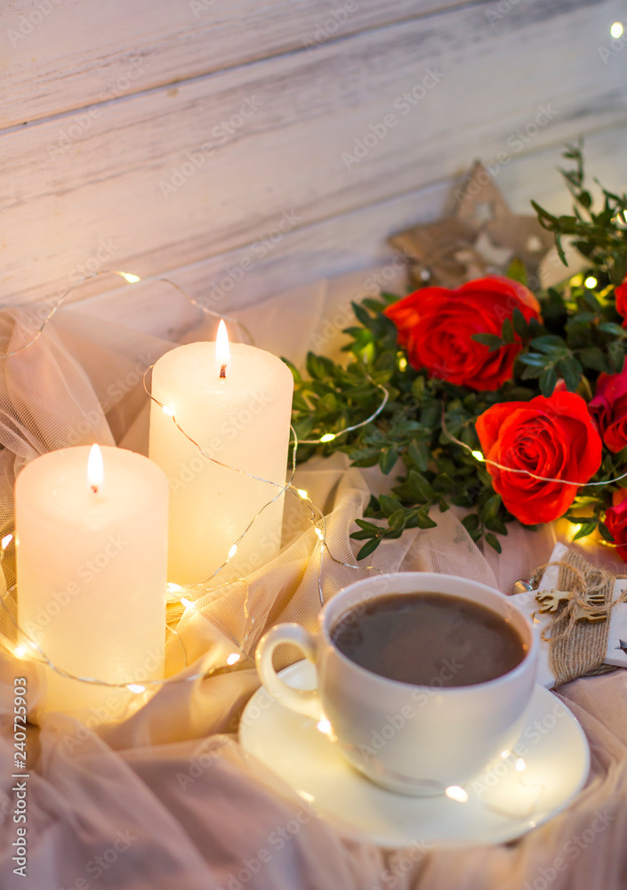 Composition: red roses with boxwood, garlands, candles, star and cup coffee (tea) Composition: red roses with boxwood, garlands, candles, star and cup coffee (tea)