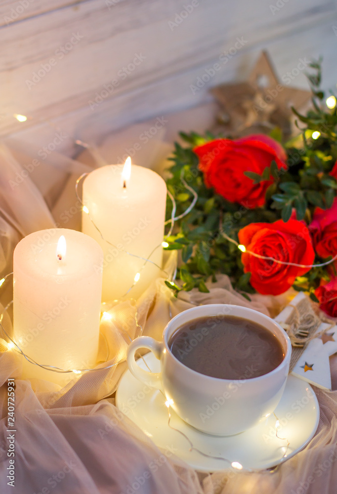 Composition: red roses with boxwood, garlands, candles, star and cup coffee (tea)