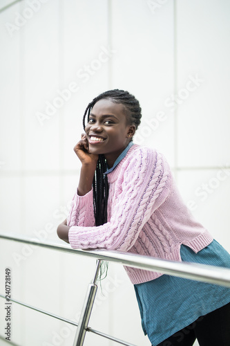 Young pretty afro american woman relaxing on handsrails in modern business office photo