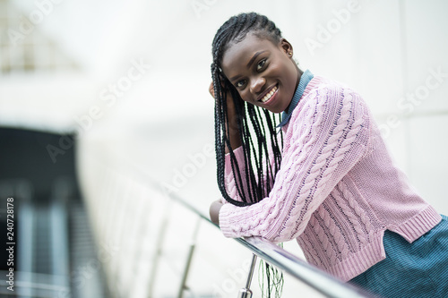 Young pretty afro american woman relaxing on handsrails in modern business office photo