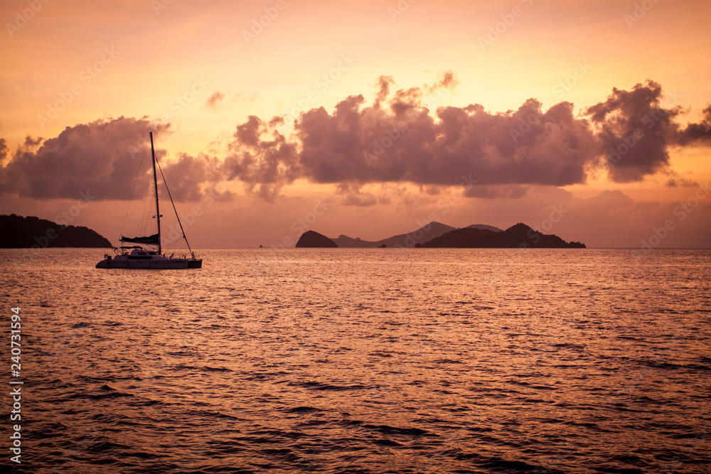 Katamaran bei Sonnenuntergang verankert vor Insel