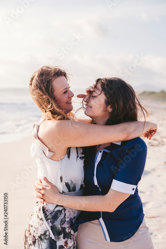 Young couple in love hug each other on the deserted beach on a summer evening