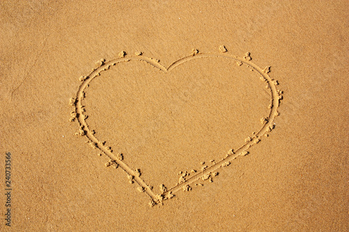 heart depicted on sea sand for background