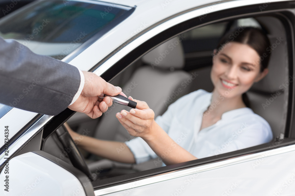 Man auto dealer offering car key to woman