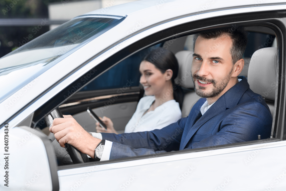 Young business couple going to work by car