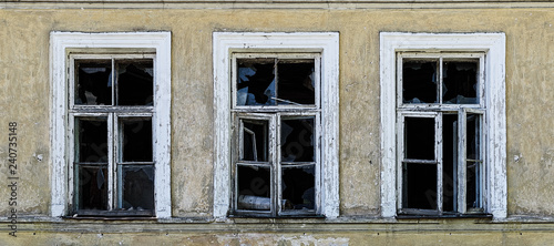 Old broken windows on an abandoned old building.